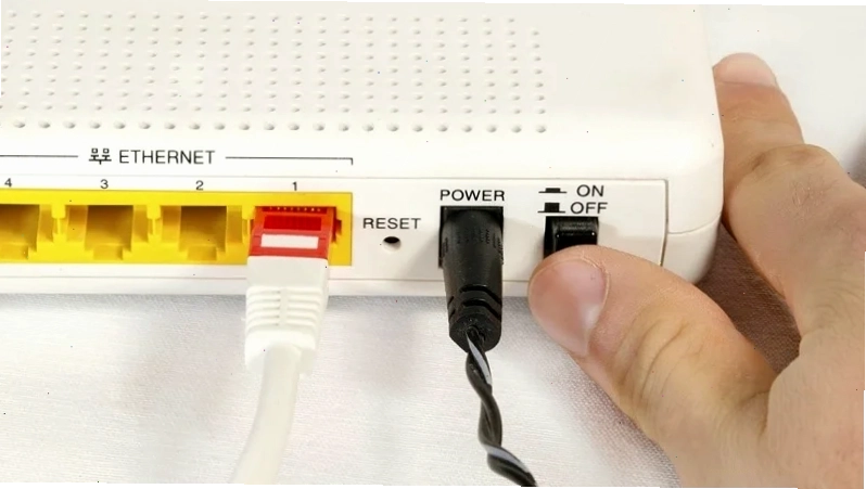 Người đàn ông đang khởi động lại router WiFi